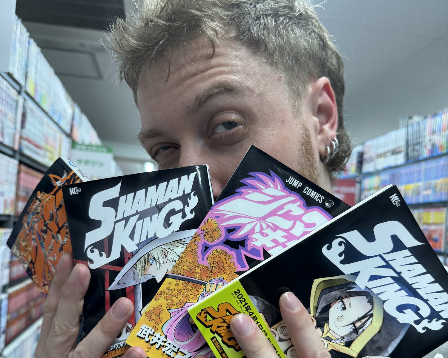 A guest holding several volumes of Shaman King in a second-hand manga shop in Akihabara